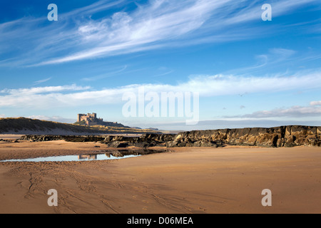 Marcher sur la plage en dessous de bamborough castle Northumberland. Banque D'Images