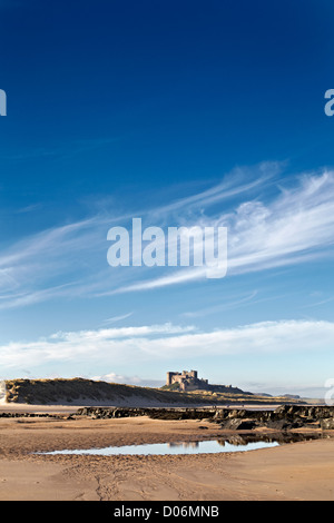 Marcher sur la plage en dessous de bamborough castle Northumberland. Banque D'Images