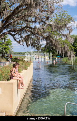 Les filles de l'adolescence s'asseoir sur le mur à Salt Springs Recreation Area dans la forêt nationale d'Ocala, Floride Banque D'Images