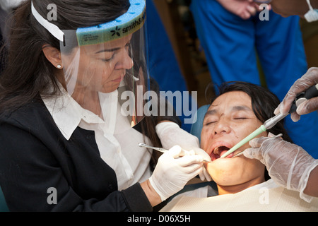 Dentiste bénévole féminin fournit des services dentaires par une mission clinique dentaire mobile sourit à Tampa, FL Banque D'Images