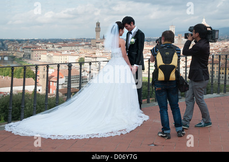 Couple chinois mariés posent pour les photographies de mariage et vidéo sur terrasse de la Piazzale Michelangelo Florence Firenze Italie Banque D'Images