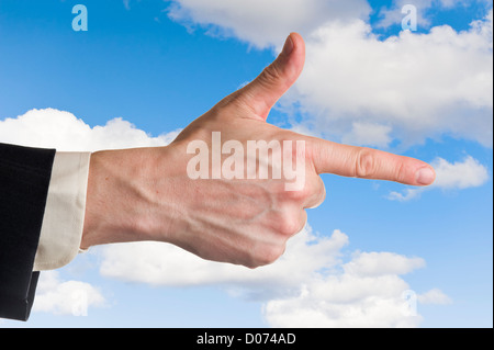 Mans part, pointant l'index, le fond de ciel bleu nuageux. Banque D'Images