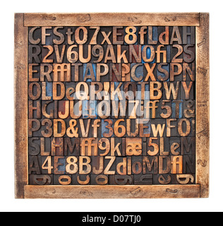 Les lettres, chiffres, symboles de ponctuation dans la typographie type vintage bois blocs placés aléatoirement dans une boîte en bois Banque D'Images