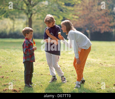 Frère et soeurs en parc, avec des glaces, Ascot, Berkshire, Angleterre, Royaume-Uni Banque D'Images