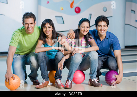 Deux jeunes couples avec des boules de bowling dans un Banque D'Images