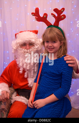 8 ans, fille de grotte avec le père Noël dans une école, noël fayre Hampshire, Royaume-Uni. Banque D'Images