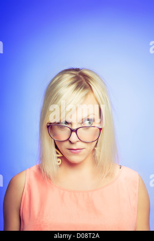 Portrait d'une jeune femme sceptique isolé sur fond bleu Banque D'Images