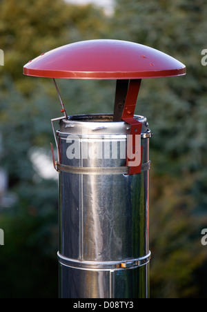 Architecture, bâtiment détail, la pluie haut bord sur la cheminée de fumée en acier inoxydable haut de poêle à bois. Banque D'Images