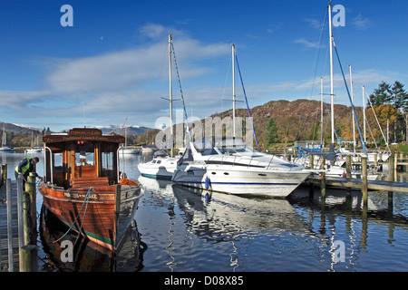 Bateaux et yachts modernes et d'un lancement traditionnel en bois amarré à Waterhead Ambleside, sur le lac Windermere en Cumbria. Banque D'Images