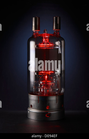 Distributeur électronique de style rétro rouge brillant sur fond bleu foncé. Banque D'Images