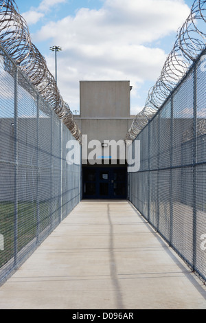 Clôture de la prison et de barbelés à la sortie d'un établissement correctionnel. Un passage étroit avec des clôtures et des barbelés enroulés. Banque D'Images