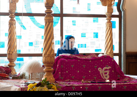 La lecture féminine Granthi Guru Granth Sahib sur Manji Sahib dans le Darbar Sahib dans Gravesend Gurdwara Guru Nanak Darbar Kent UK Banque D'Images