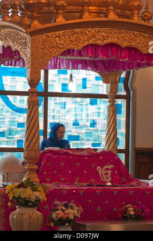La lecture féminine Granthi Guru Granth Sahib sur Manji Sahib dans le Darbar Sahib dans Gravesend Gurdwara Guru Nanak Darbar Kent UK Banque D'Images