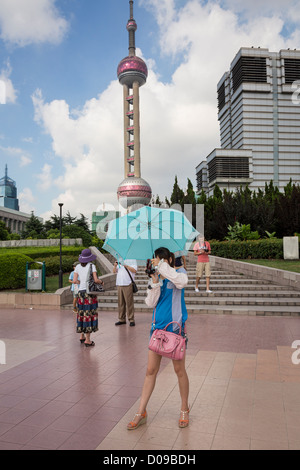 Un touriste chinois prendre une photo le long de la promenade le long du fleuve dans le secteur Pudong de Shanghai, Chine Banque D'Images