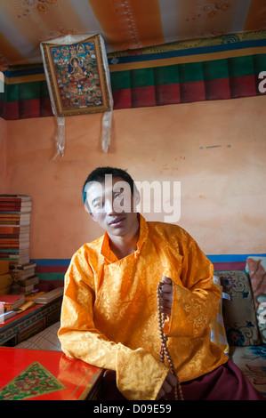 Jeune moine bouddhiste Sherab juine à l'intérieur de quartiers personnels, Sangrgompa Monastère, Lac Namtso, Tibet, Chine Banque D'Images