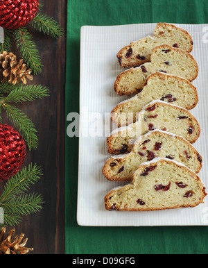 Couper en morceaux Christmas Stollen sur une assiette, à côté de décorations de Noël Banque D'Images