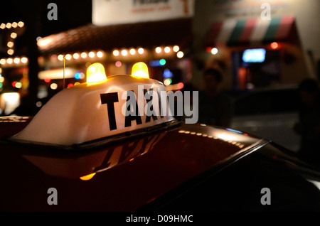 Signe sur un taxi dans la rue la nuit Banque D'Images