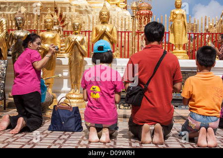 Femme thaïlandaise photographier sa famille priant devant les statues de Bouddha du Wat Phra That Doi Suthep TEMPLE CHIANG MAI THAÏLANDE ASIE Banque D'Images