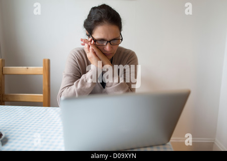 Femme lisant sur un ordinateur portable Banque D'Images