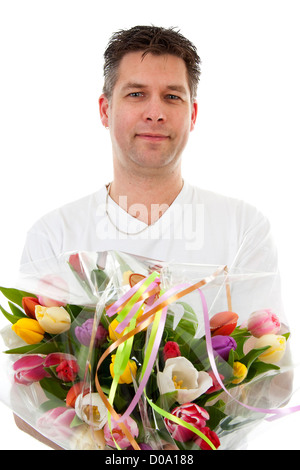 Jeune homme donne à bouquet de tulipes colorées sur fond blanc Banque D'Images