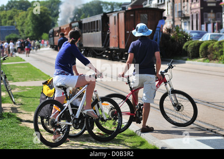 Un couple de cyclistes À À PEU DE TOURISME BAIE DE SOMME DE LA LOCOMOTIVE À VAPEUR EN GARE SAINT-VALERY-SUR-SOMME SOMME (80) Banque D'Images