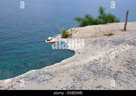 Section de route s'est effondrée. Les plantes qui poussent à travers broken edge d'asphalte en ruine fissurés. Banque D'Images