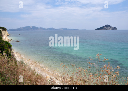 La plage vide érodée dans la baie de Laganas, Zante, Grèce. Vue éloignée sur l'îlot Marathonisi caretta naturel de l'habitat des tortues de mer. Banque D'Images