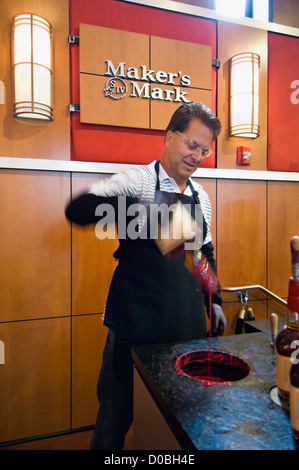 L'homme son trempage bouteille Bourbon Maker's Mark dans la cire à la Distillerie Maker's Mark Loretto, Kentucky Banque D'Images