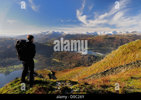 Walker admiring view du Nab cicatrice dans le Lake District. Rydal Water, Grasmere et fells couvertes de neige dans la distance Banque D'Images