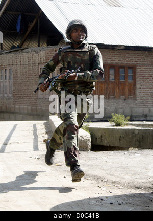 Soldat de l'armée indienne se dirige vers la maison où militants sont masquer lors d'une fusillade dans la banlieue de Srinagar, Inde - Banque D'Images