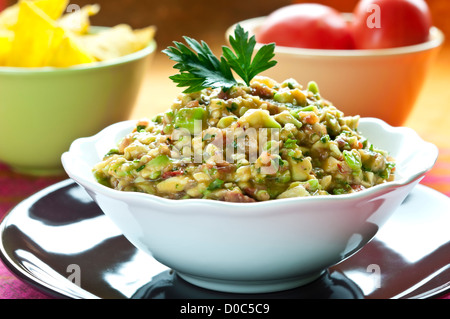 Salade Guacamole disposés en bol blanc de persil sur le dessus Banque D'Images