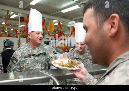 Brig. Gen. Bud R. Jameson Jr., commandant général du 316th Sustainment Command (expéditionnaire), remet un repas de Thanksgiving à un soldat au Camp Arifjan, Koweït, le 22 novembre 2012. Le repas s’inscrivait dans une tradition des fêtes pour soutenir les soldats déployés pendant la saison. Banque D'Images