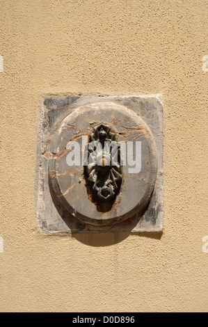 Vieille porte bell situé dans une plaque de marbre à côté d'une porte à Lucques Toscane Italie Banque D'Images