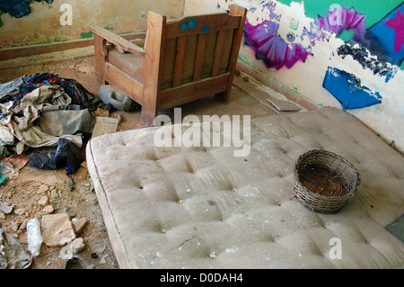 Matelas et des vêtements sales sur le plancher d'une maison abandonnée. Banque D'Images