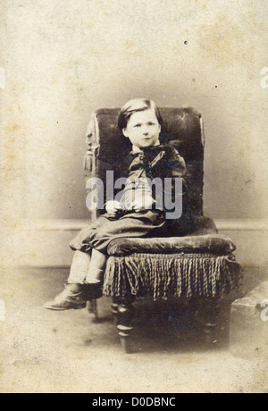 Portrait de jeune garçon sur une chaise. Carte de cabinet vintage photographie par A.D. Lewis, Newcastle on Tyne, Royaume-Uni, vers 1870. Banque D'Images