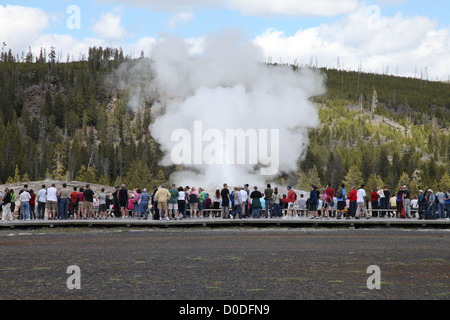 Les touristes regarder Old Faithful Geyser, Yellowstone National Park, Wyoming, USA Banque D'Images
