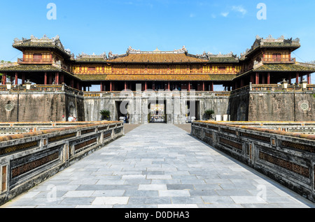 HUE, Vietnam — la porte de la Citadelle de l'autre côté du pont de la ville impériale de Hue, Vietnam. Palais clos et fortifié, le complexe comprend la Cité interdite pourpre, qui était le sanctuaire intérieur de la maison impériale, ainsi que des temples, des cours, des jardins et d'autres bâtiments. Une grande partie de la ville impériale a été endommagée ou détruite pendant la guerre du Vietnam. Il est maintenant classé au patrimoine mondial de l'UNESCO. Banque D'Images