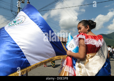 ANTIGUA GUATEMALA, Guatemala — dans la matinée de la veille de la fête de l’indépendance du Guatemala (célébrée le 15 septembre), des centaines d’écoliers d’Antigua et des villages environnants défilent dans un défilé de groupes scolaires à Antigua, certains en costume et d’autres en uniforme scolaire. Le défilé comprend également des orchestres de marche de l'école et des cheerleaders. Le cortège commence au Parque Central et passe devant l'église jaune vif de la Merced et sur le stade municipal. Banque D'Images