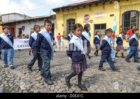 ANTIGUA GUATEMALA, Guatemala — dans la matinée de la veille de la fête de l’indépendance du Guatemala (célébrée le 15 septembre), des centaines d’écoliers d’Antigua et des villages environnants défilent dans un défilé de groupes scolaires à Antigua, certains en costume et d’autres en uniforme scolaire. Le défilé comprend également des orchestres de marche de l'école et des cheerleaders. Le cortège commence au Parque Central et passe devant l'église jaune vif de la Merced et sur le stade municipal. Banque D'Images