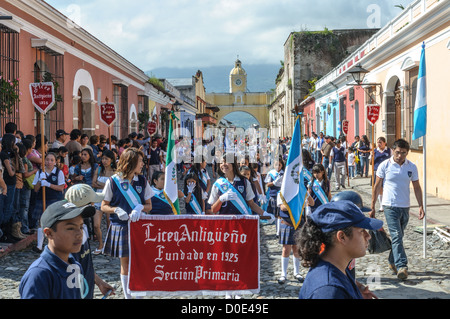 ANTIGUA GUATEMALA, Guatemala — dans la matinée de la veille de la fête de l’indépendance du Guatemala (célébrée le 15 septembre), des centaines d’écoliers d’Antigua et des villages environnants défilent dans un défilé de groupes scolaires à Antigua, certains en costume et d’autres en uniforme scolaire. Le défilé comprend également des orchestres de marche de l'école et des cheerleaders. Le cortège commence au Parque Central et passe devant l'église jaune vif de la Merced et sur le stade municipal. Banque D'Images