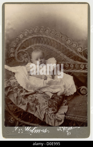 Portrait de studio victorien de bébé mignon photographié sur un canapé en rotin ou en bambou, canapé, Lytham, Lancashire, Angleterre, Royaume-Uni, vers 1890 Banque D'Images