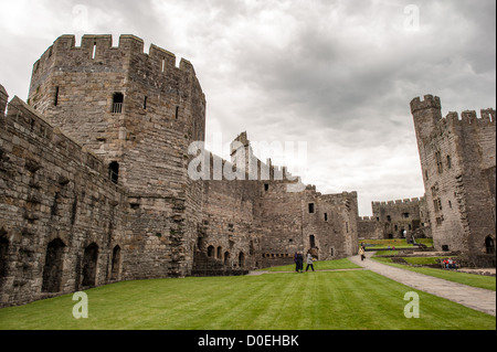CAERNARFON, pays de Galles — remparts vus depuis la cour intérieure du château de Caernarfon, dans le nord-ouest du pays de Galles. Un château se trouvait à l'origine sur le site datant de la fin du XIe siècle, mais à la fin du XIIIe siècle, le roi Édouard Ier a commandé une nouvelle structure qui se dresse aujourd'hui. Le château présente des tours polygonales distinctives et fait partie de l'anneau de fer d'Édouard Ier des fortifications construites pour consolider sa conquête du pays de Galles. Le château de Caernarfon est largement considéré comme l'un des plus beaux exemples de l'architecture militaire de la fin du XIIIe et du début du XIVe siècle en Europe. La forteresse a servi de siège à l'adm anglais Banque D'Images