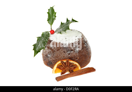 Le pudding de Noël décoré avec Holly, d'épices et d'orange blanc isolé contre Banque D'Images