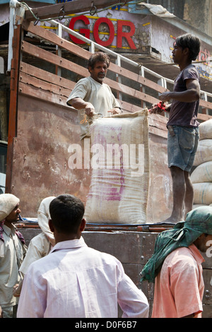 Décharger un camion de travailleurs avec des sacs de ciment à Mumbai, Inde Banque D'Images