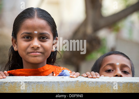 Happy Indian girl and boy à plus d'un mur. L'Andhra Pradesh, Inde Banque D'Images