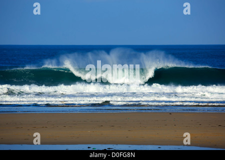 Portreath, Cornwall. Une vague se brise sur la plage. Banque D'Images