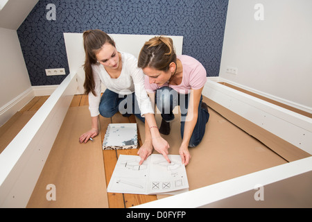 Mère et fille assembler des meubles, lit. Faire vous-même. Amélioration de l'habitat. Banque D'Images