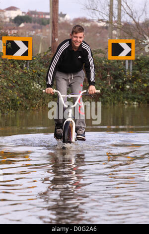 Street, Somerset, England, UK - 25 novembre 2012. Les routes secondaires entre Glastonbury et Street près de la rivière Brue a été inondée - jeunes ont l'occasion d'avoir du plaisir dans les inondations. Banque D'Images