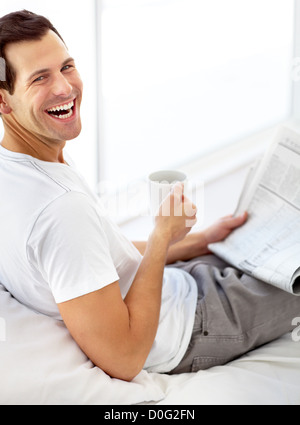 Young male, bénéficie d''un café le matin tout en lisant le journal Banque D'Images