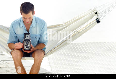 Jeune homme prend une photographie avec un appareil photo antique Banque D'Images